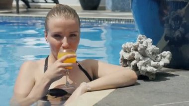 Bir bardak portakal suyu içen gülümseyen bir kadının portresi