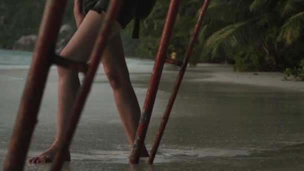 Giovane donna bionda in piedi da sola sulla spiaggia e guardando il tramonto . — Video Stock