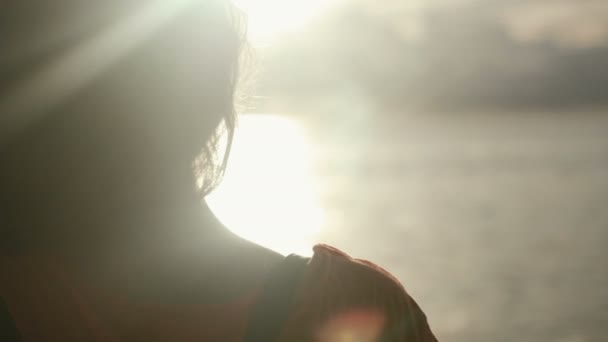 El primer plano de la silueta de la mujer joven en la puesta del sol. Vista trasera . — Vídeo de stock