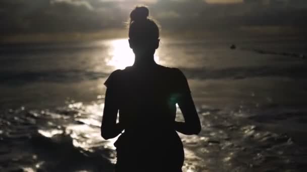 Silhueta mulher sobre o céu por do sol, sombra preta do corpo feminino com as mãos para cima . — Vídeo de Stock