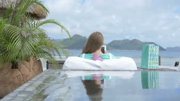 Woman in hotel lounge using digital tablet during vacation, outdoors. — Stock Video