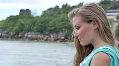 Tropikal tatil ahşap iskele üzerinde duran dalgın genç kadın portresi.