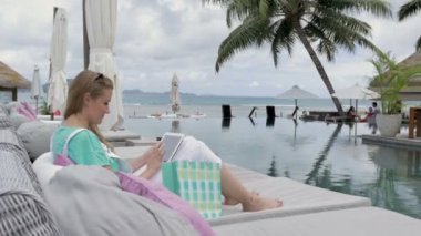 Kadın lüks otel tatil sırasında açık havada dijital tablet kullanma.