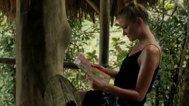 Jeune femme séduisante avec carte de l'île jouissant dans la jungle . — Video