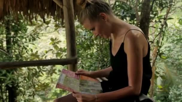 Joven mujer atractiva con mapa de isla disfrutando en la selva . — Vídeos de Stock