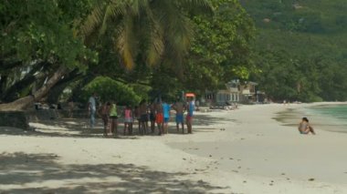 Turistler ve yerliler Beau Vallon Plajı'nda Mahe Batı.