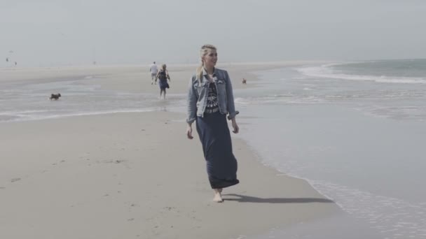 Retrato de una joven caminando en la playa con los brazos extendidos y la cara levantada en el cielo disfrutando de la paz . — Vídeos de Stock