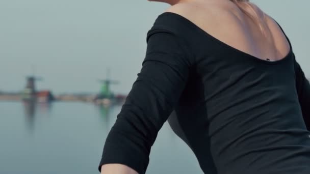 Junge Frau in der Stadt zaanse schans in Holland steht auf der Brücke und genießt die Aussicht. — Stockvideo