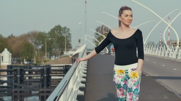 Mujer joven en la ciudad Zaanse Schans en Holanda de pie en el puente y disfrutando de la vista . — Vídeo de stock