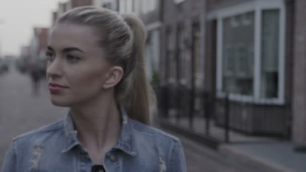 Beautiful young woman walking in the city street during autumn time. — Stock Video