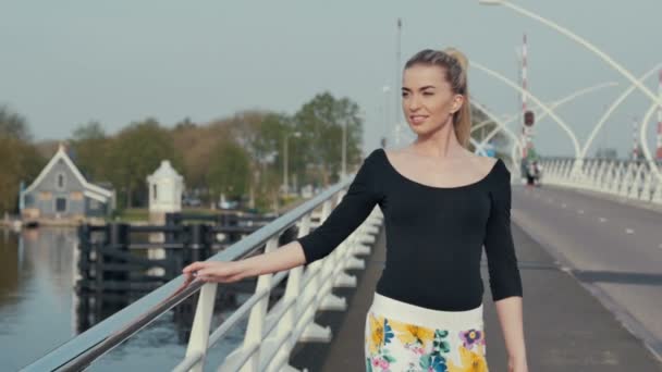 Jovem mulher na cidade Zaanse Schans na Holanda de pé na ponte e desfrutando da vista . — Vídeo de Stock