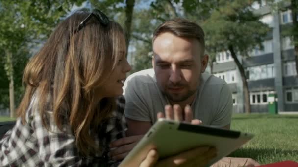 Šťastný pár pomocí digitálních tabletu v parku. — Stock video