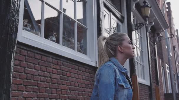 Unga blonda kvinnan väntar på någon, utomhus. — Stockvideo