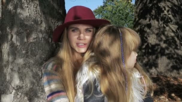 Madre che abbraccia la sua dolce figlia in un parco autunnale soleggiato, all'aperto . — Video Stock