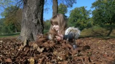 Küçük kız açık havada sonbahar parkta oynarken.