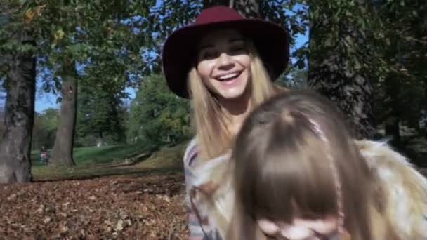 Маленькая девочка развлекается с мамой в осеннем парке . — стоковое видео
