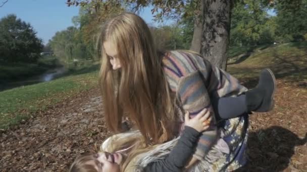 Petite fille s'amuser avec sa mère dans le parc d'automne .