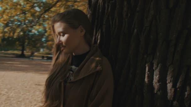 日当たりの良い紅葉公園で美しい一日を楽しんで若いブロンドの女の子. — ストック動画