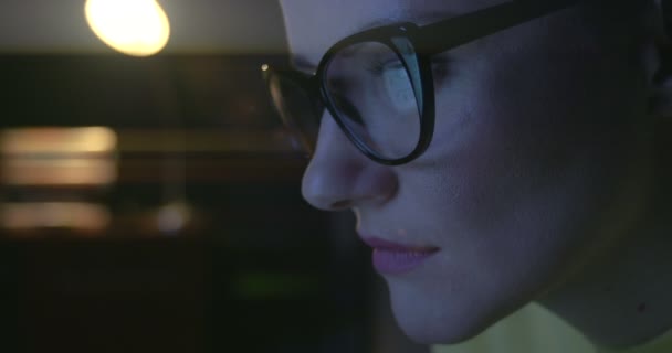 Close up of woman's eyes in glasses surfing on Internet. — Stock Video