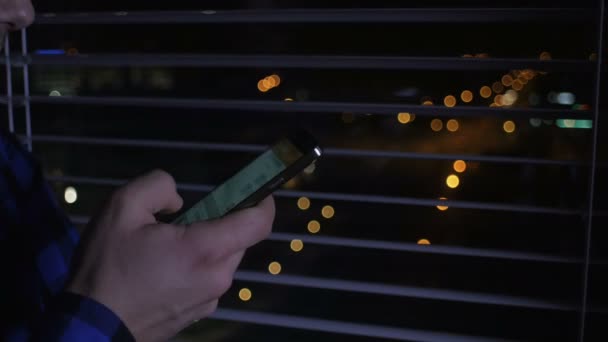 Gros plan d'un homme utilisant un smartphone mobile la nuit . — Video