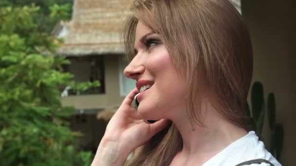 Vrouw praten over telefoon terwijl u geniet van vakantie in tropisch resort. — Stockvideo