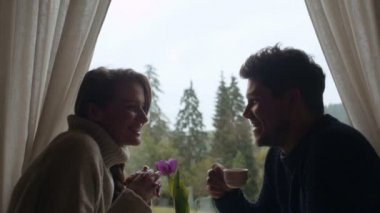 Genç çift romantik bir akşam yemeği yerken öpüşme.