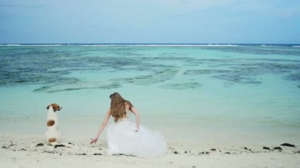 Young bride with a dog looking at beautiful ocean. — Stock Video
