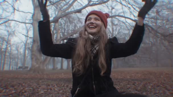 Happy young woman in gloomy autumnal park. — Stock Video