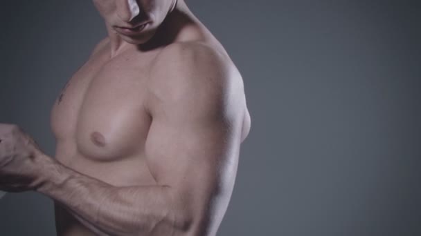 Bodybuilder poseren op donkere achtergrond. — Stockvideo