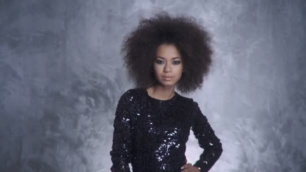 Joven mujer elegante con afro sosteniendo chispas y sonriendo a una cámara . — Vídeos de Stock