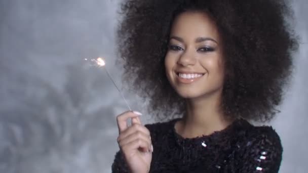 Closeup beauty portrait of young girl holding sparklers over silver background. — Stock Video