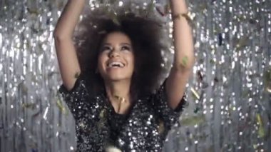 Güzel afro Amerikalı kadın altın konfeti, ağır çekim arasında dans.