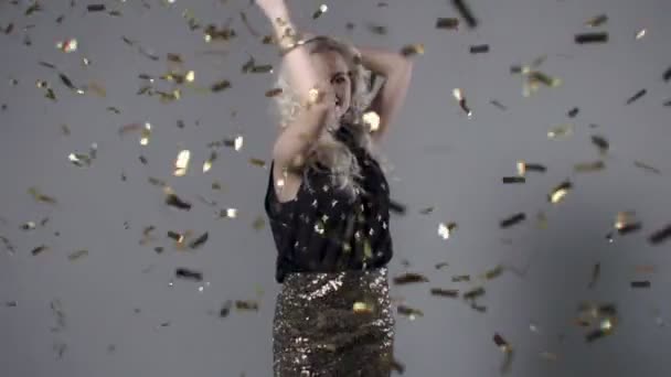 Beautiful woman among golden confetti, slow motion. — Stock Video