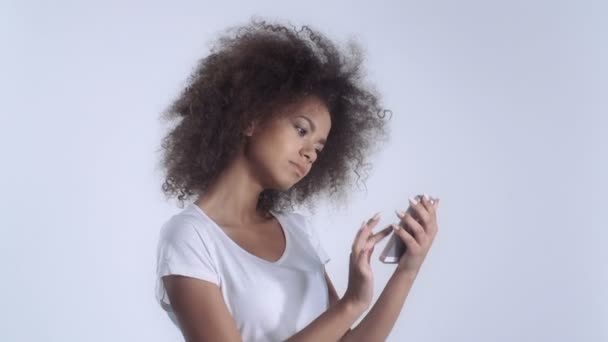 Jeune fille mulâtre avec téléphone portable en studio . — Video