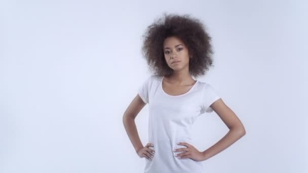 Mladá Američanka afro pohlaví v bílé tričko vystupují nad bílým pozadím. — Stock video