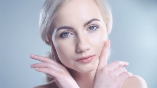 Mooie lachende vrouw aanraken van haar gezicht geïsoleerd op witte achtergrond. — Stockvideo