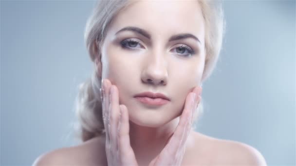 Beautiful smiling woman touching her face isolated over white background. — Stock Video