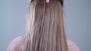 Gri arka plan üzerinde izole uzun sarı saçlı sevimli kız.