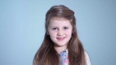 Gri arka plan üzerinde izole uzun sarı saçlı sevimli kız.