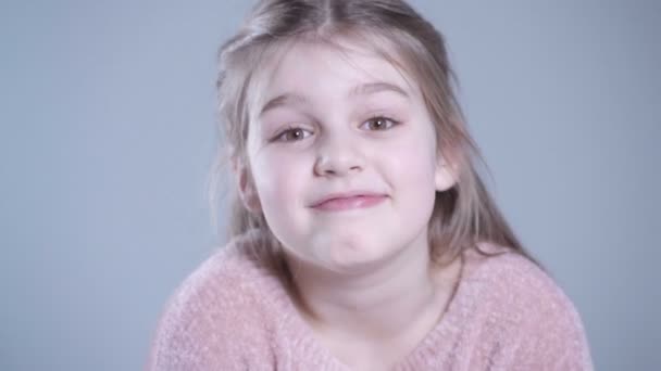 Cute girl with long blonde hair isolated over gray background. — Stock Video