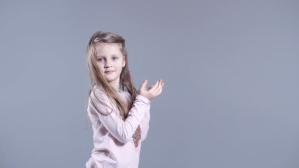 Милая девушка с длинными светлыми волосами изолированы на сером фоне . — стоковое видео