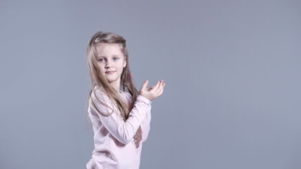 Ragazza carina con lunghi capelli biondi isolati su sfondo grigio . — Video Stock