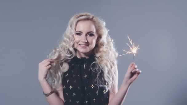 Closeup beauty portrait of young girl holding sparklers over grey background. — Stock Video