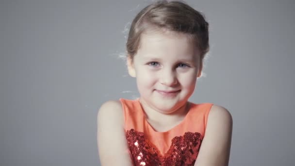 Мила дівчина з довгим світлим волоссям позує на сірому фоні . — стокове відео