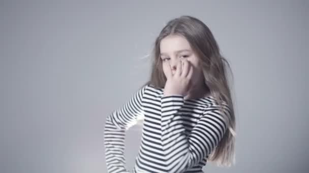 Portret van mooie kindermodel meisje met lang haar poseren in studio. — Stockvideo