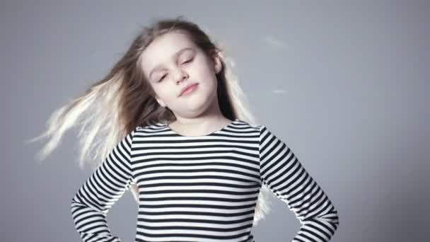 Portrait de belle enfant fille modèle avec les cheveux longs posant en studio . — Video