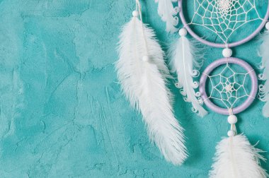 Aquamarine arka planında leylak kremi beyaz rüya yakalayıcısı. Metin için alanı kopyala.