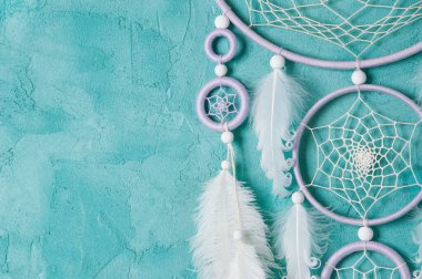 Aquamarine arka planında leylak kremi beyaz rüya yakalayıcısı. Metin için alanı kopyala.