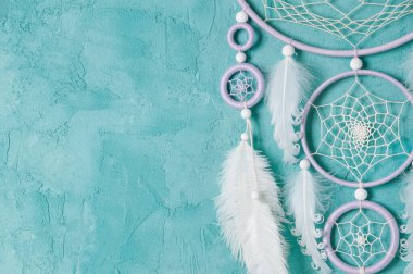 Aquamarine arka planında leylak kremi beyaz rüya yakalayıcısı. Metin için alanı kopyala.