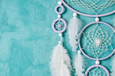 Aquamarine arka planında leylak kremi beyaz rüya yakalayıcısı. Metin için alanı kopyala.